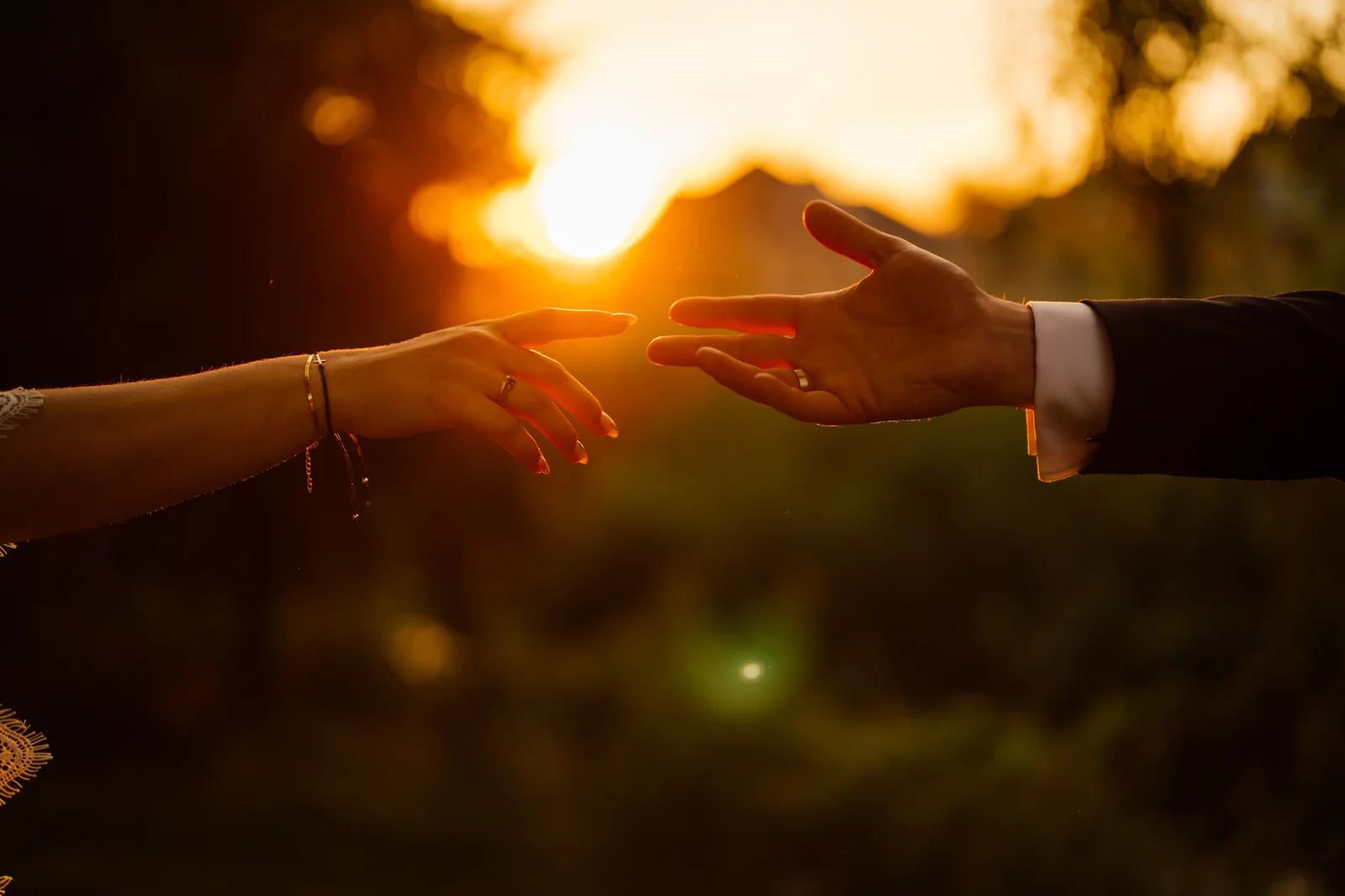 Dłonie pary młodej przy zachodzie słońca